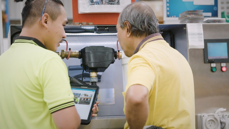 Team members standing next to equipment are logging an issue when it happened. This helps to develop problem solving skills.